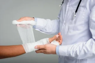 Doctor puting bandage on hand